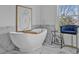 Close up of luxurious, free-standing tub and a gold accent table with high stool at 2850 Stonehall Se Ct, Smyrna, GA 30080