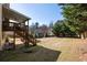 Spacious backyard featuring a well-maintained lawn, a wooden deck, and mature trees at 4012 Grand Park Ne Dr, Suwanee, GA 30024