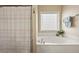 Bright bathroom showcases a tub with shower curtain and a window at 4012 Grand Park Ne Dr, Suwanee, GA 30024