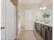 Well-lit bathroom with a double vanity, dark cabinets, and a tiled floor at 4012 Grand Park Ne Dr, Suwanee, GA 30024