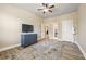 Spacious bedroom has hardwood floors, ceiling fan, dresser with TV and doorway view to ensuite at 4012 Grand Park Ne Dr, Suwanee, GA 30024
