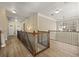 Upstairs hallway with wood floors, updated lighting, and wood and iron railing at 4012 Grand Park Ne Dr, Suwanee, GA 30024