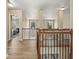 Upstairs hallway features wood floors, updated lighting, and a view of the downstairs at 4012 Grand Park Ne Dr, Suwanee, GA 30024