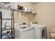 Laundry room with washer, dryer, and storage shelves at 4012 Grand Park Ne Dr, Suwanee, GA 30024