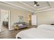 Main bedroom with hardwood floors, tray ceilings, seating area, and view into the en-suite bathroom at 4012 Grand Park Ne Dr, Suwanee, GA 30024