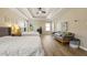 Bright main bedroom with tray ceilings, hardwood floors, and a comfortable seating area at 4012 Grand Park Ne Dr, Suwanee, GA 30024
