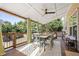 Relaxing covered patio with wood floors, ceiling fan, dining set, and views of backyard trees at 4012 Grand Park Ne Dr, Suwanee, GA 30024