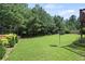 Green backyard surrounded by lush trees, providing a serene and private outdoor space at 4249 Caveat Ct, Fairburn, GA 30213