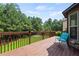 View of the stained wood deck with wood railing and a seat with views of the trees at 4249 Caveat Ct, Fairburn, GA 30213