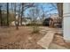 View of the backyard with mature trees, a deck with stairs, and a concrete patio at 5257 Orly Ter, Atlanta, GA 30349