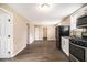 The kitchen and connecting room features wood-look floors, and black kitchen appliances at 5257 Orly Ter, Atlanta, GA 30349