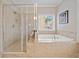A well-lit bathroom featuring a soaking tub and a glass-enclosed shower at 2625 Draw Dr, Marietta, GA 30066
