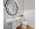 Elegant half bath features pedestal sink, decorative mirror, and board and batten, great for guests at 2625 Draw Dr, Marietta, GA 30066