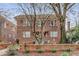 Beautiful exterior of a well-maintained brick building, framed by mature trees and a low brick wall with manicured shrubs at 1111 Briarcliff Ne Pl # 2, Atlanta, GA 30306