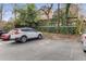 A parking lot showing parking spaces available at property with parked cars, greenery, and a building in the background at 1111 Briarcliff Ne Pl # 2, Atlanta, GA 30306