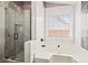 Elegant bathroom featuring a marble-tiled shower with glass door and a luxurious soaking tub with a window view at 395 Shadetree Ln, Lawrenceville, GA 30044
