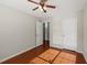 Bright bedroom featuring hardwood floors, ceiling fan, and two closets for storage at 395 Shadetree Ln, Lawrenceville, GA 30044