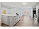Kitchen island with white cabinets, laminate floor, white countertop, and stainless appliances at 395 Shadetree Ln, Lawrenceville, GA 30044