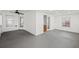 Large empty room with windows, ceiling fan, and grey flooring at 395 Shadetree Ln, Lawrenceville, GA 30044