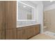 Modern bathroom with a double sink vanity, illuminated mirror, and walk-in shower with bench at 775 Juniper Ne St # 111, Atlanta, GA 30308