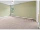 Spacious bedroom with light-green walls, plush carpet, a ceiling fan, and a sunlit window at 1439 Mill Pointe Ct, Lawrenceville, GA 30043