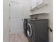 Functional laundry room with washer, dryer, storage cabinets, and shelving at 1439 Mill Pointe Ct, Lawrenceville, GA 30043