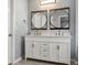 Well-lit bathroom featuring a white double vanity with round framed mirrors at 1851 Millwood Park Ct, Buford, GA 30518