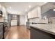 Modern kitchen with stainless steel appliances, gray lower cabinets, white upper cabinets, and hardwood floors at 1851 Millwood Park Ct, Buford, GA 30518