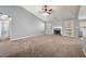 Large carpeted living room with fireplace, ceiling fan, and neutral paint colors creates a comfortable space at 1851 Millwood Park Ct, Buford, GA 30518