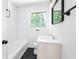 Bright bathroom features a shower-tub combo with modern fixtures, hexagon floor tiles and a window at 5726 Southwick Sw Ct, College Park, GA 30349