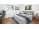 Serene bedroom with hardwood floors, a tufted headboard, and large windows overlooking greenery at 5726 Southwick Sw Ct, College Park, GA 30349