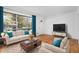 Bright living room with hardwood floors, large window with curtains, modern furniture, and white walls at 5726 Southwick Sw Ct, College Park, GA 30349