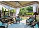 Relaxing covered patio features stylish furniture, ceiling fan, and serene backyard view at 108 Summer Breeze Ln, Canton, GA 30114