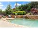 An in-ground backyard pool with stone waterfall feature and professionally landscaped yard at 108 Summer Breeze Ln, Canton, GA 30114