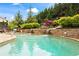 A backyard pool with waterfalls surrounded by lush landscaping and stone accents at 108 Summer Breeze Ln, Canton, GA 30114