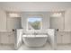 Modern bathroom featuring a soaking tub, double vanities, and natural light from the window at 141 Frontier Way, Mcdonough, GA 30253