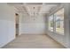 Dining room featuring hardwood floors, white paneled walls, a modern chandelier, and a large window at 141 Frontier Way, Mcdonough, GA 30253