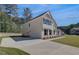 Side view of a two-story home with a long driveway and an attached garage at 141 Frontier Way, Mcdonough, GA 30253