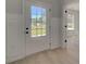 Bright foyer featuring hardwood floors, white wainscoting, and a glass panel exterior door at 141 Frontier Way, Mcdonough, GA 30253