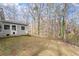 View of the home's backyard featuring a partial view of a sunroom and mature trees at 1925 Emerald Dr, Cumming, GA 30040