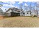 View of the home's backyard featuring mature trees and a sunroom addition at 1925 Emerald Dr, Cumming, GA 30040