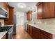 Galley kitchen featuring granite counters, stainless steel appliances, tile backsplash and wood cabinets at 1925 Emerald Dr, Cumming, GA 30040