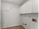 Neutral laundry room with white cabinets, hook for hanging and utility connections on the wall at 1925 Emerald Dr, Cumming, GA 30040