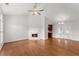 Bright living room featuring hardwood floors, fireplace, ceiling fan, and doors leading to an adjacent space at 1925 Emerald Dr, Cumming, GA 30040