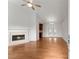 Bright living room with hardwood floors, a fireplace, ceiling fan, and double doors leading to another room at 1925 Emerald Dr, Cumming, GA 30040