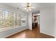 Bright sunroom with large windows, neutral paint, hardwood floors, ceiling fan and view into kitchen at 1925 Emerald Dr, Cumming, GA 30040