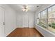 Bright sunroom with large windows, neutral paint, hardwood floors, ceiling fan and two access doors at 1925 Emerald Dr, Cumming, GA 30040