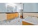 Bright bathroom features a vanity with light wood cabinetry, a soaking tub, and gray tiled floor at 613 Rock Springs Pass, Dallas, GA 30157