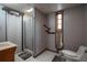 Bathroom has a shower with a laundry room sign, toilet, and a window with a view of the outdoors at 613 Rock Springs Pass, Dallas, GA 30157