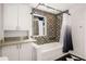 Well-lit bathroom features a shower-tub combo, stylish tile, and storage at 1175 Kingsley Ne Cir, Atlanta, GA 30324